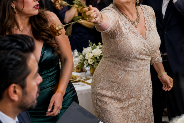 “¡Tomen, pobres, no merecen más!”, gritó mi suegra mientras arrojaba tres claveles marchitos frente a mis padres en sus bodas de oro, y mi esposo apenas sonrió. Yo no discutí: llevaba semanas guardando facturas infladas, transferencias sospechosas y contratos ligados a su departamento. Cuando acomodé un clavel detrás de su vestido, Teresa todavía no sabía que aquella noche podía costarle mucho más que su orgullo.